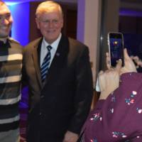 An alumna takes a photo of T.Haas and an alumnus